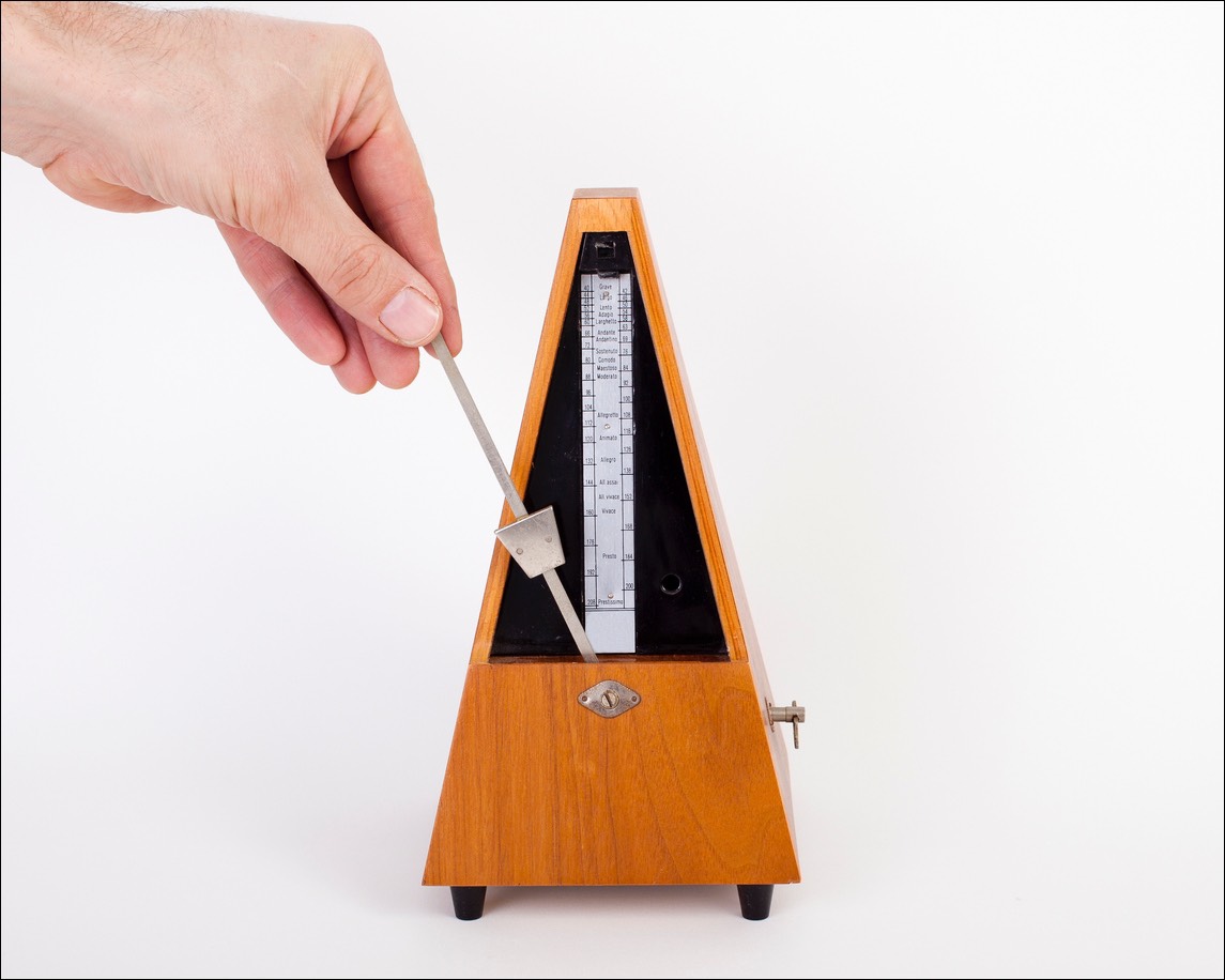 A male hand setting a metronome